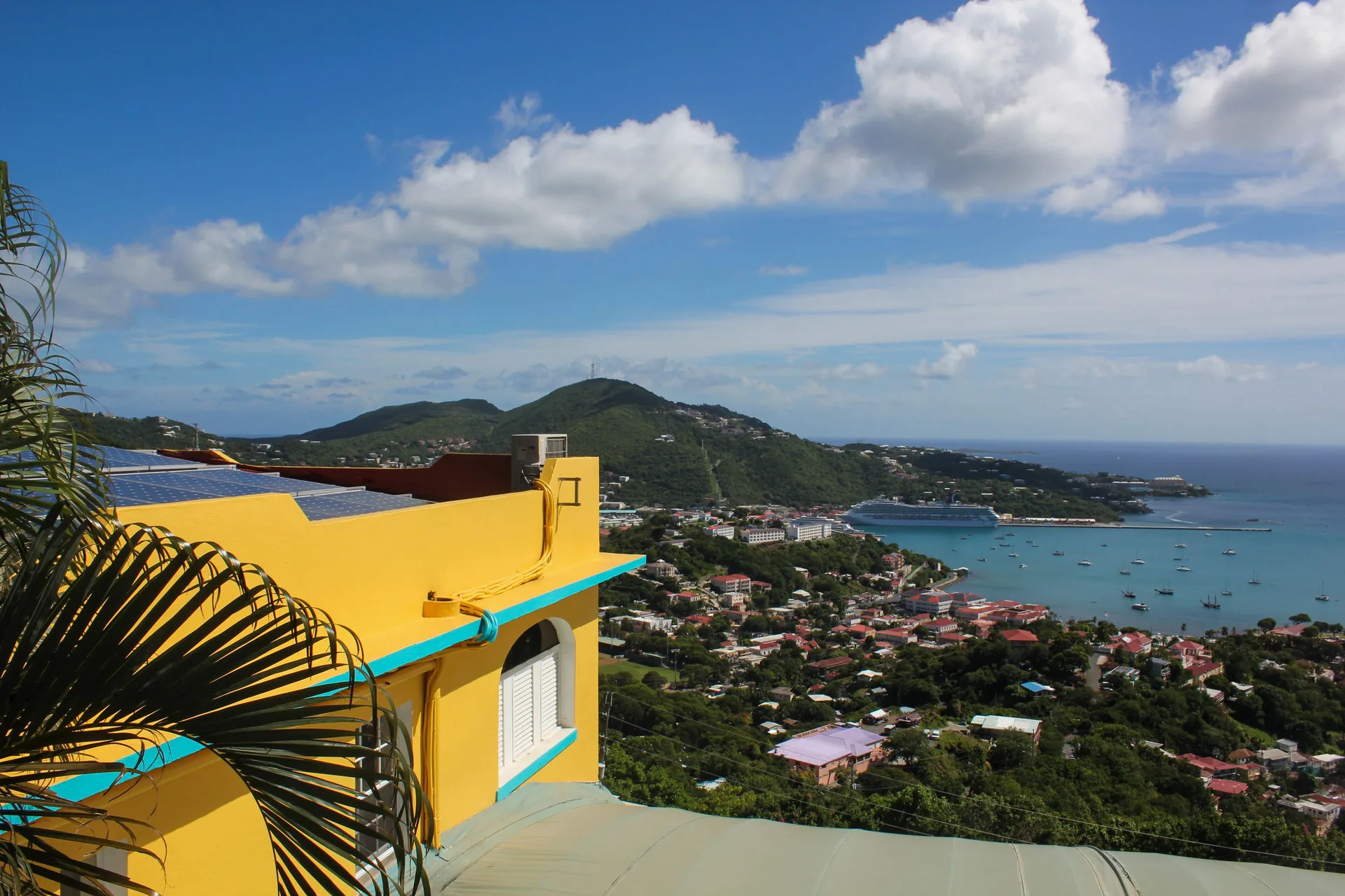 Yellow hotel building and hillside harbor view at Mafolie Hotel.