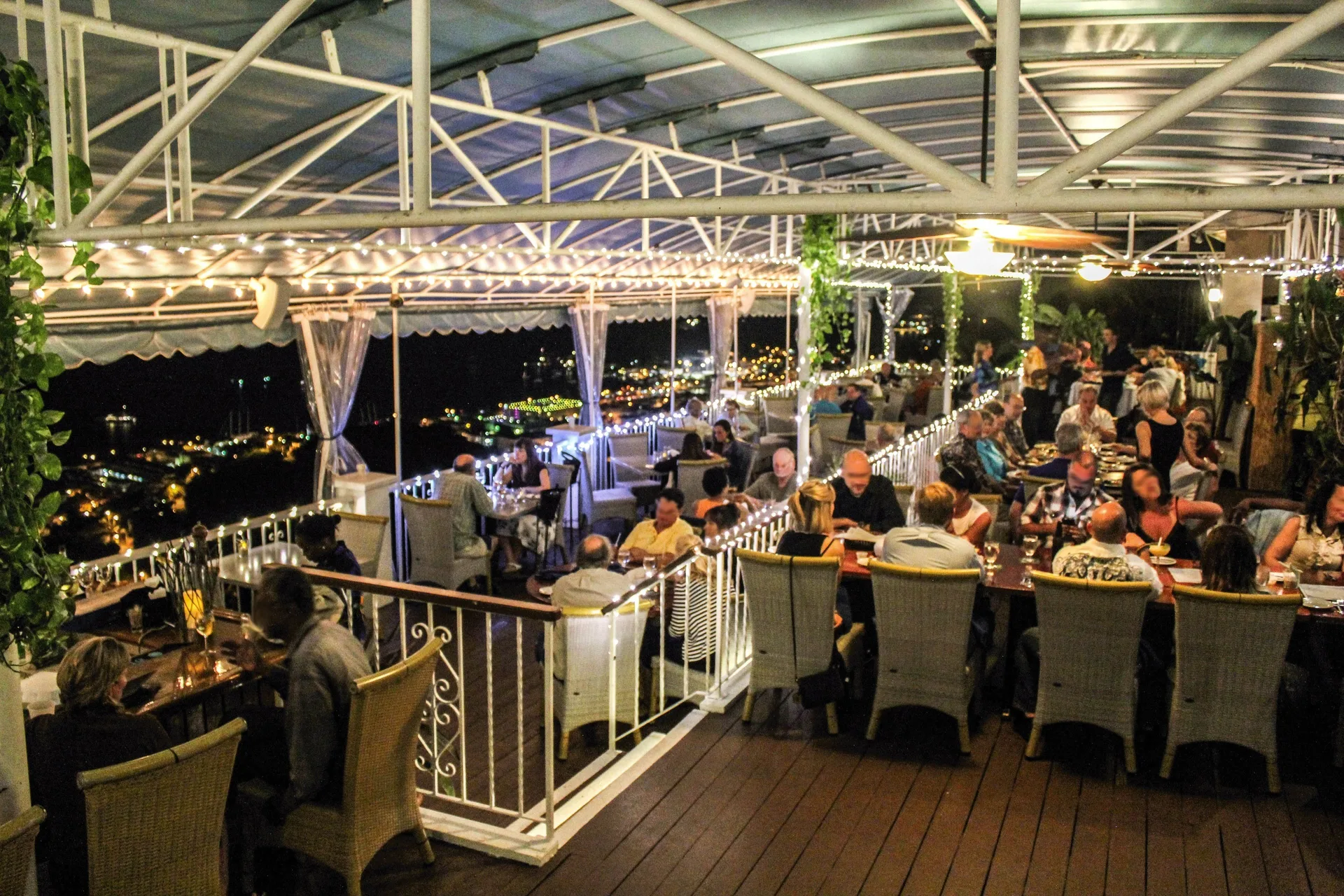 Diners fill an open-air terrace restaurant at Mafolie Hotel under string lights at night.
