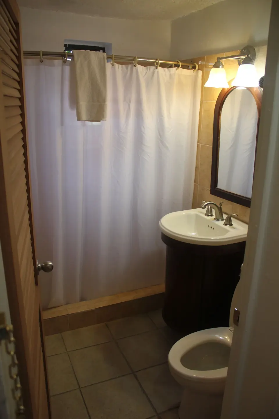 Junior Suite Harbor View bathroom with shower curtain and vanity at Mafolie Hotel.