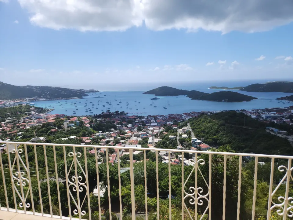 Panoramic Villa balcony view over harbor, islands, and boats at Mafolie Hotel.