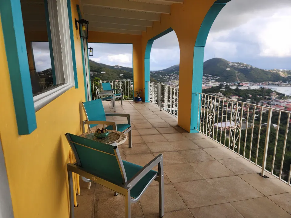 Panoramic Villa balcony with turquoise chairs and harbor view at Mafolie Hotel.