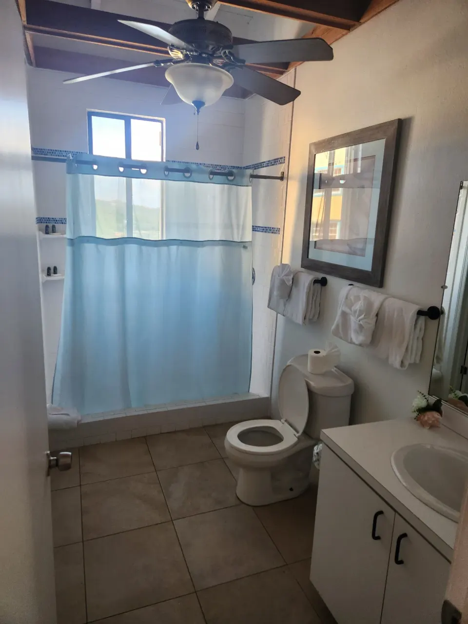 Panoramic Villa bathroom with tub shower, toilet, vanity, and towels at Mafolie Hotel.