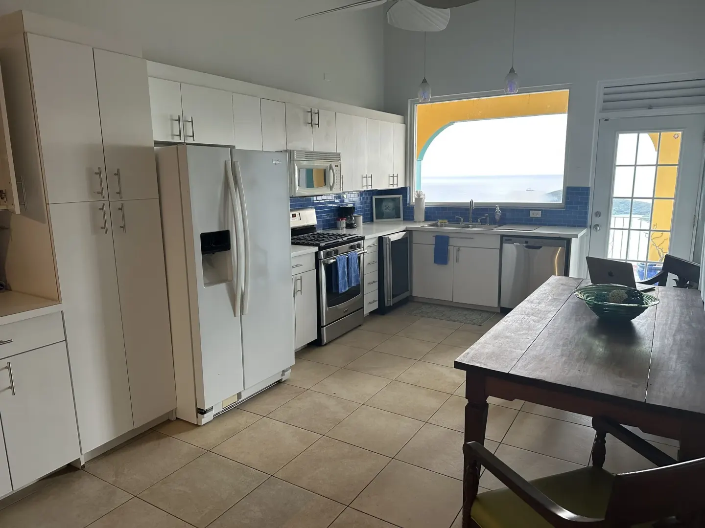 Panoramic Villa kitchen at Mafolie Hotel with white cabinets, appliances, and a sea-facing window.