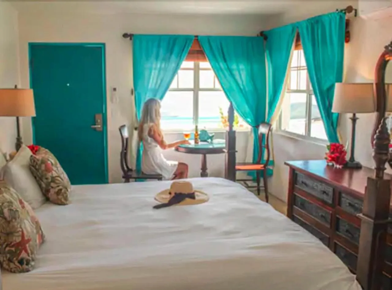 Standard Room with bed, turquoise curtains, dresser, and window seating at Mafolie Hotel.