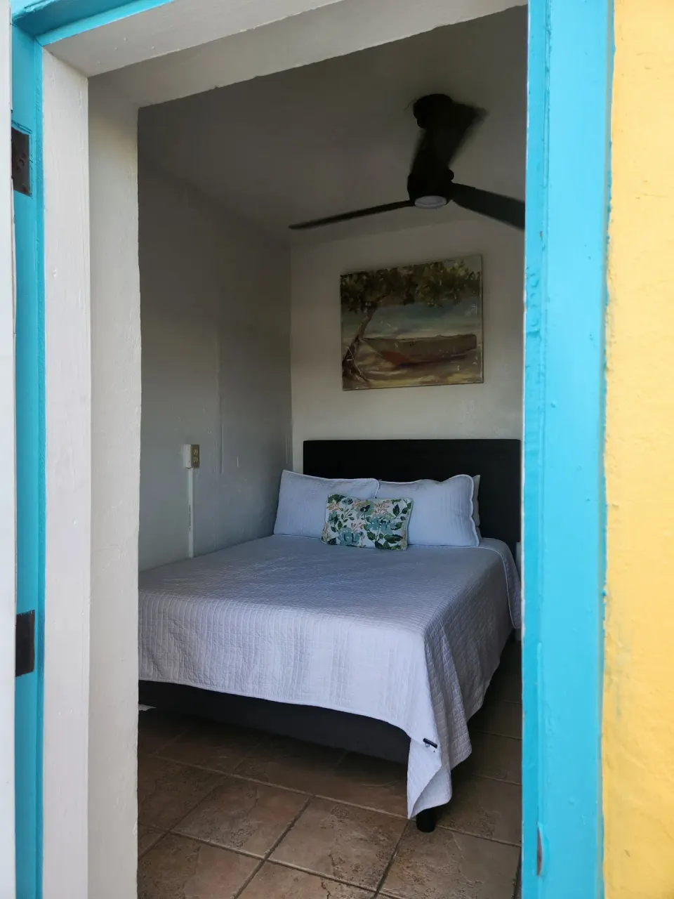 Tiny Room with a full bed seen through a turquoise doorway at Mafolie Hotel.