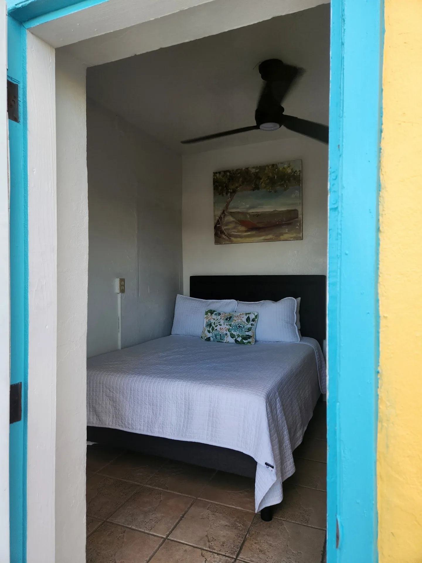 Tiny Room with a full bed seen through a turquoise doorway at Mafolie Hotel.
