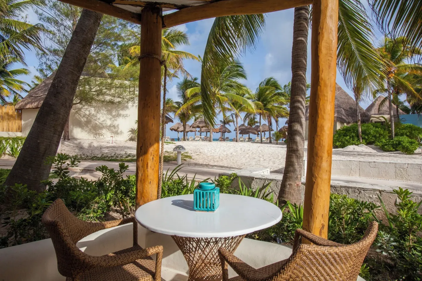 Shaded terrace table overlooking the beach at Mahekal Beach Front Resort & Spa.