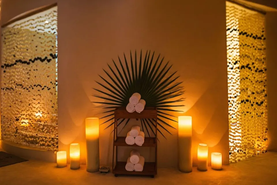 Spa display of candles and towels with palm frond backdrop at Mahekal Beach Front Resort & Spa