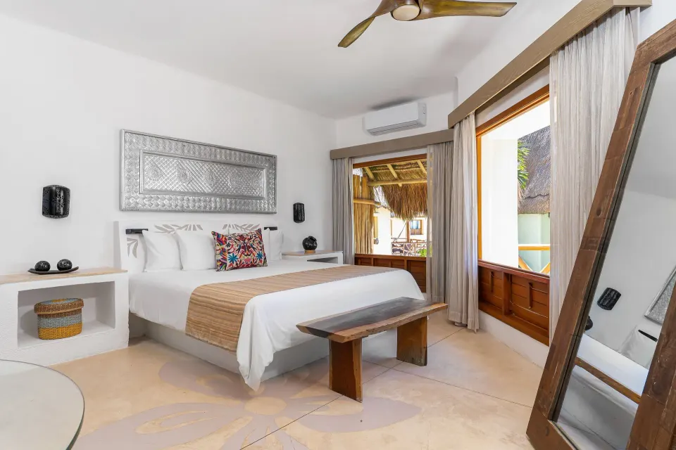 King bedroom with large window and full-length mirror at Mahekal Beach Front Resort & Spa