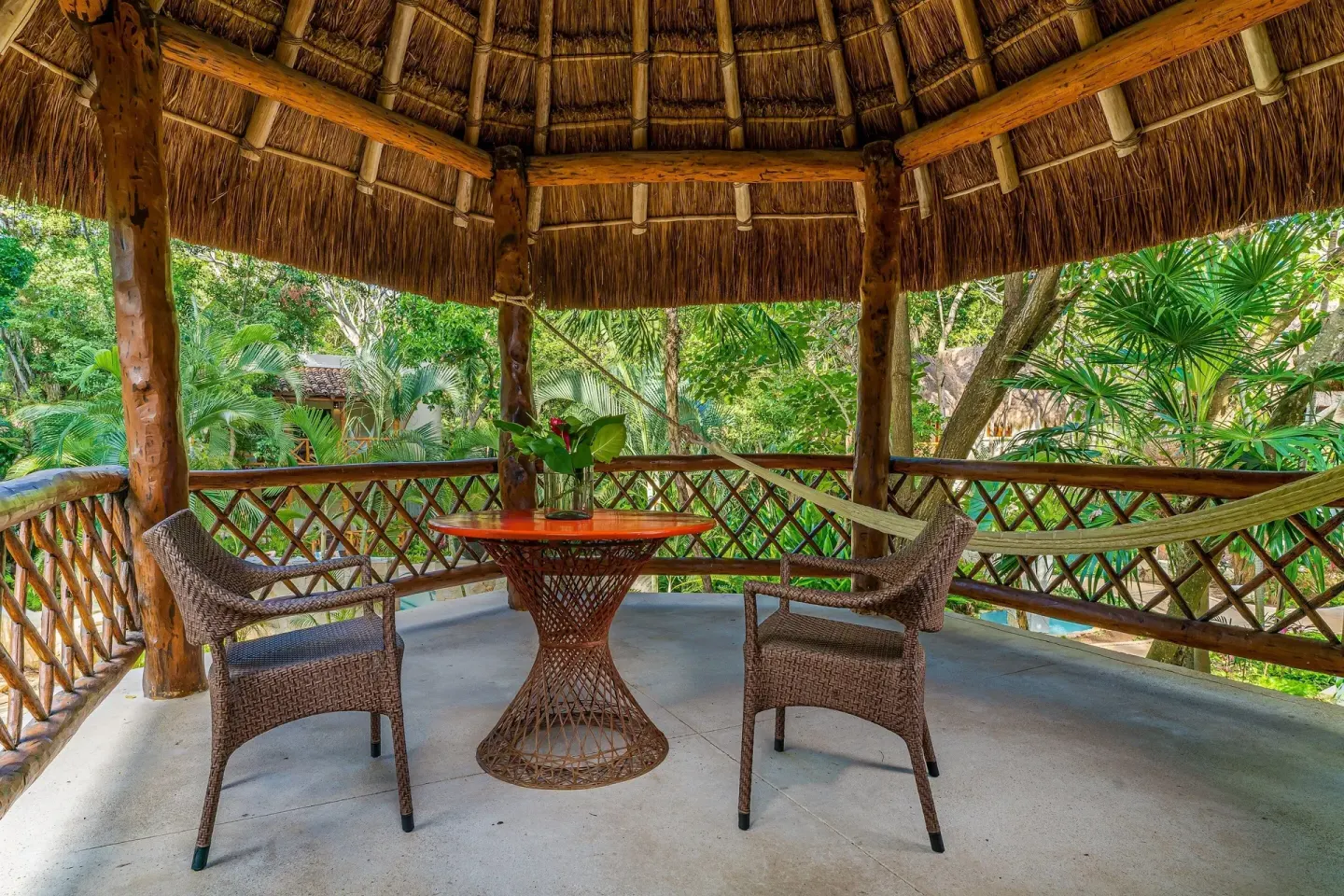 Garden-view palapa terrace with chairs and a hammock at Mahekal Beach Front Resort & Spa.