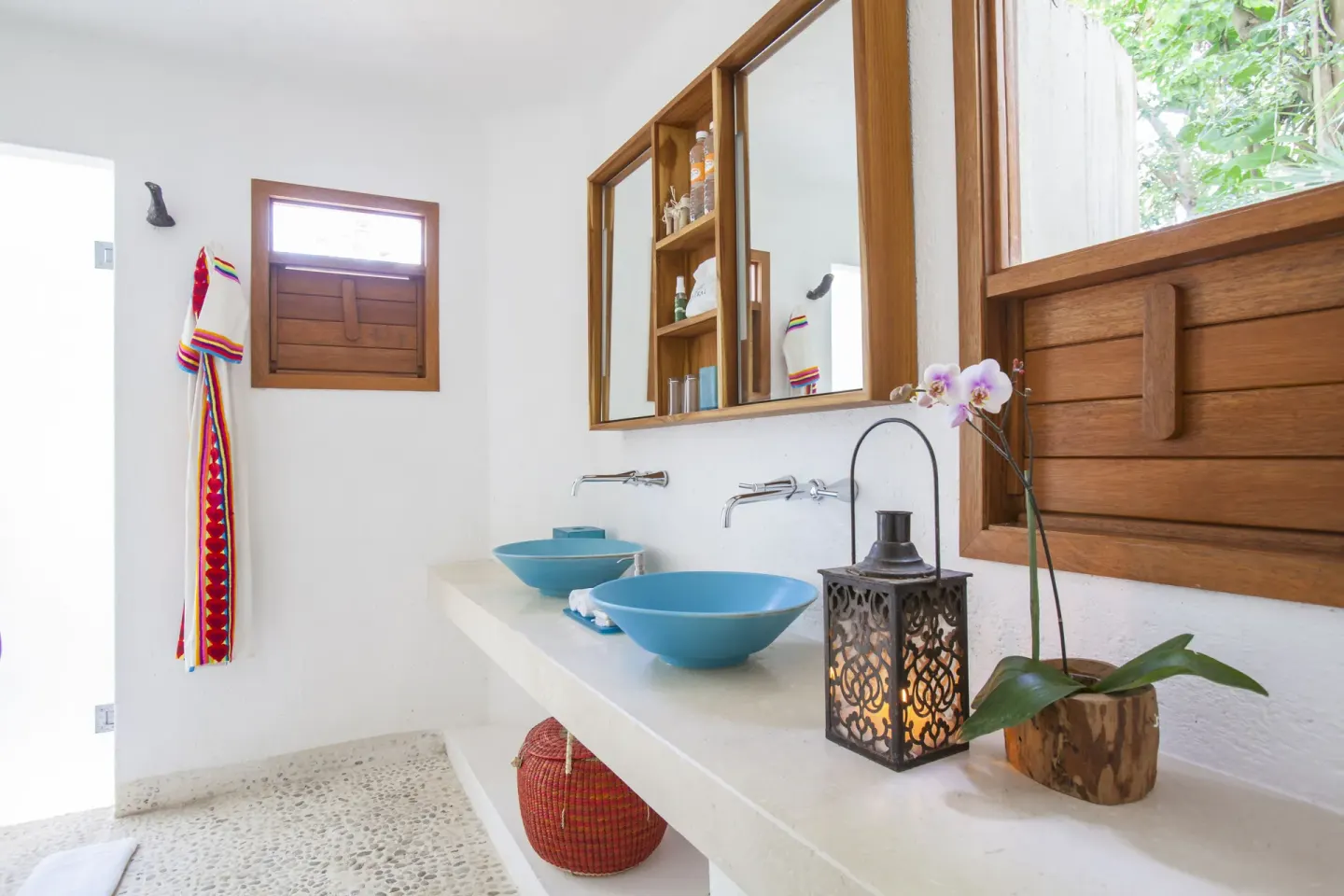 Guest bathroom with blue vessel sinks at Mahekal Beach Front Resort & Spa.