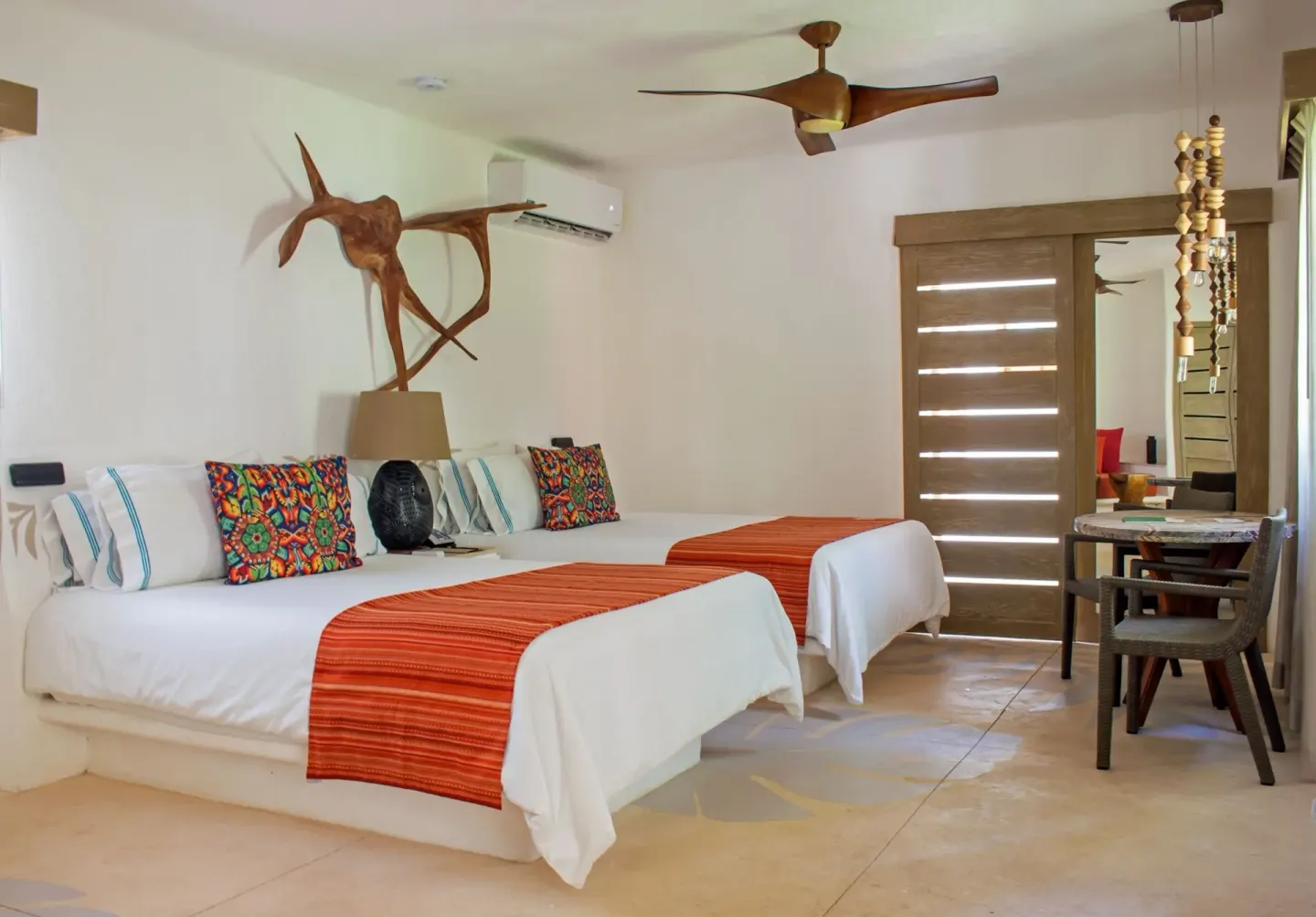 Guest room with two beds and orange runners at Mahekal Beach Front Resort & Spa.
