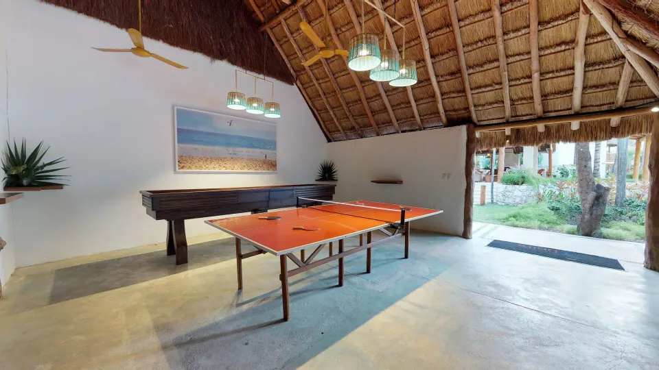 Thatched palapa game room with ping-pong table at Mahekal Beach Front Resort & Spa