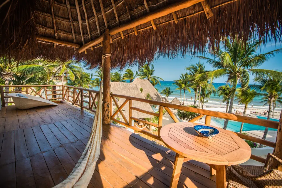 Wooden balcony with hammock and ocean view at Mahekal Beach Front Resort & Spa