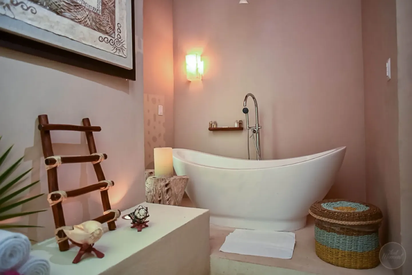 Freestanding bathtub with candles and woven accents at Mahekal Beach Front Resort & Spa.