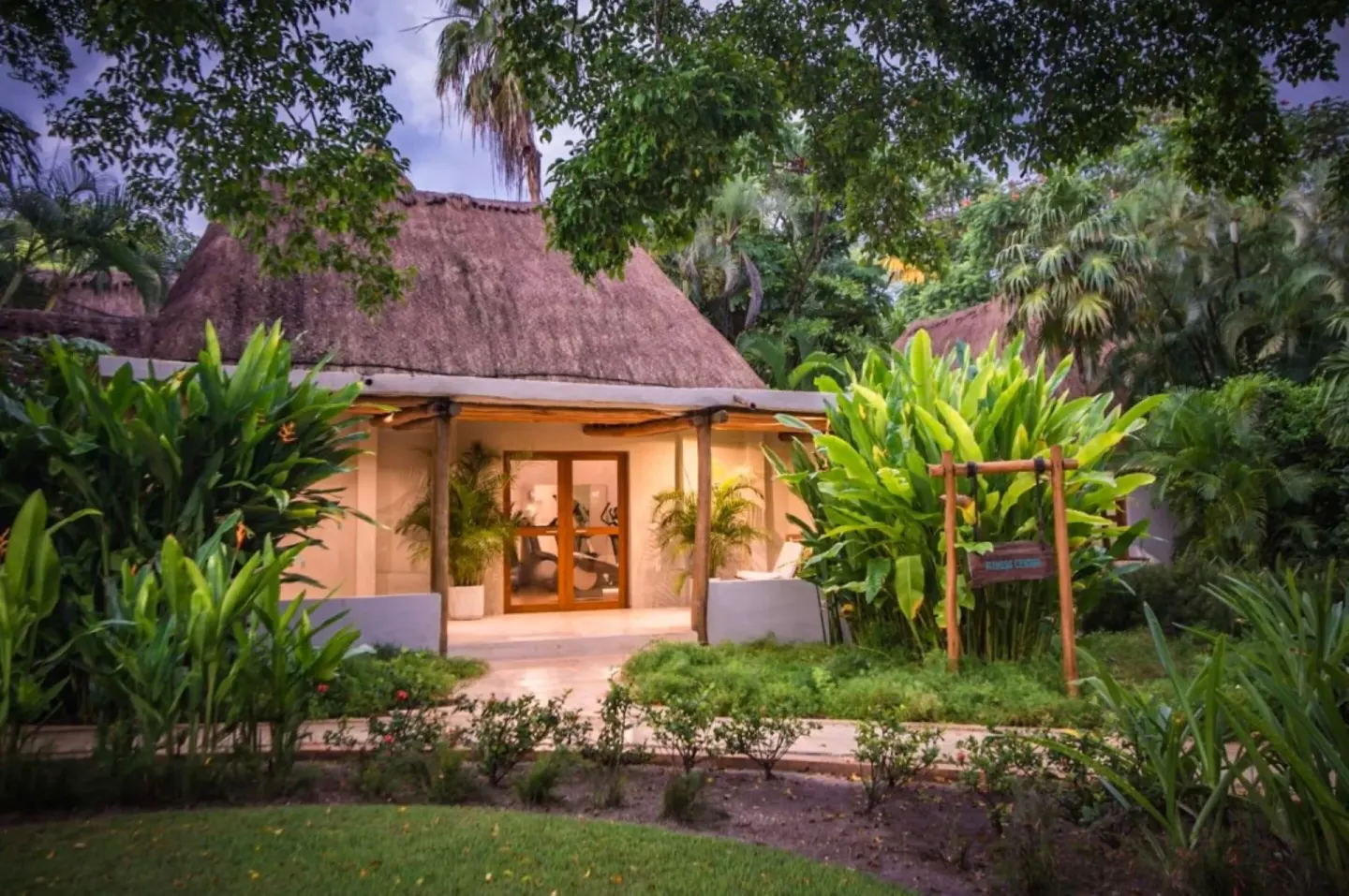 Thatched spa building among lush gardens at Mahekal Beach Front Resort & Spa.