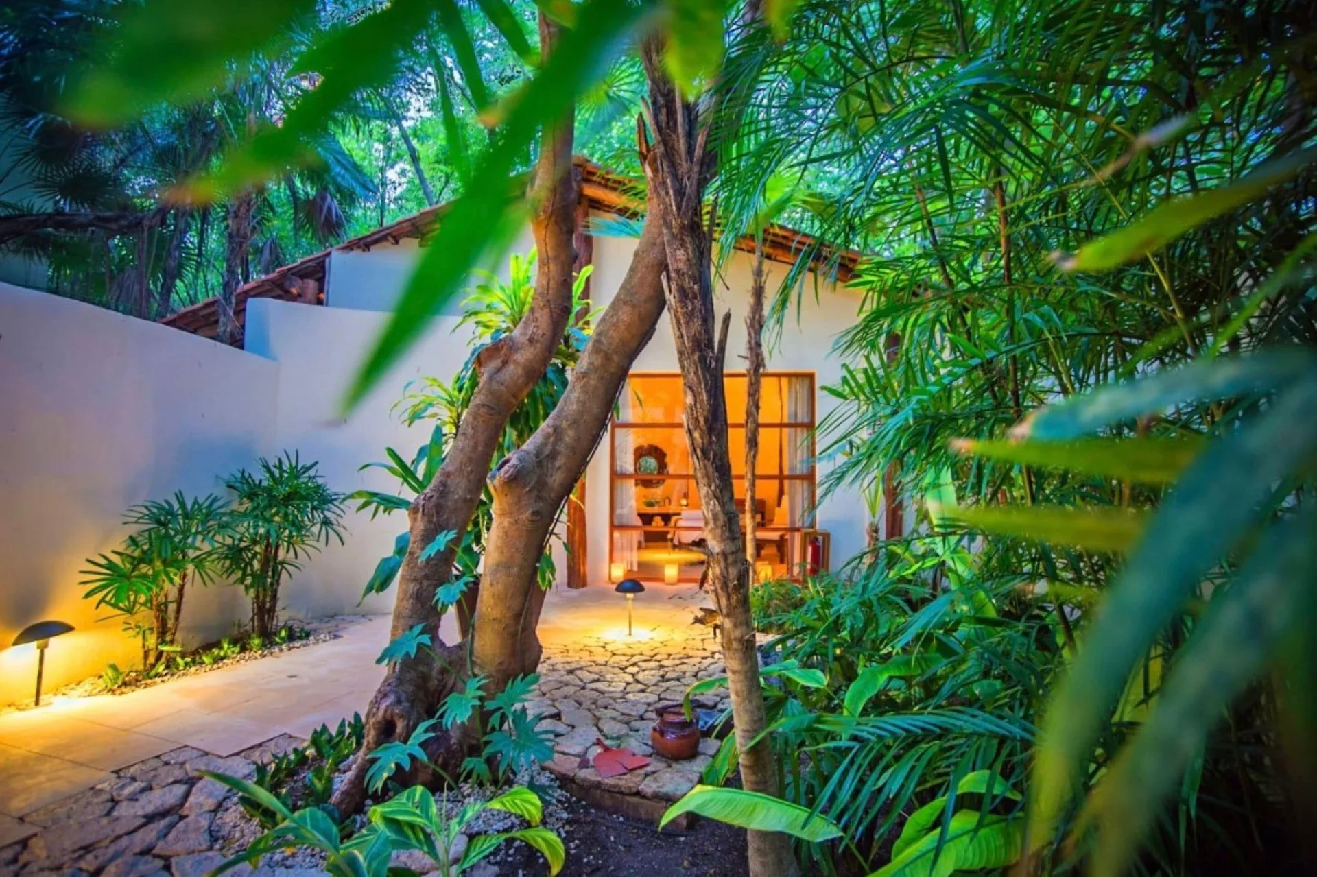 Tropical garden path leading to a spa room at Mahekal Beach Front Resort & Spa.