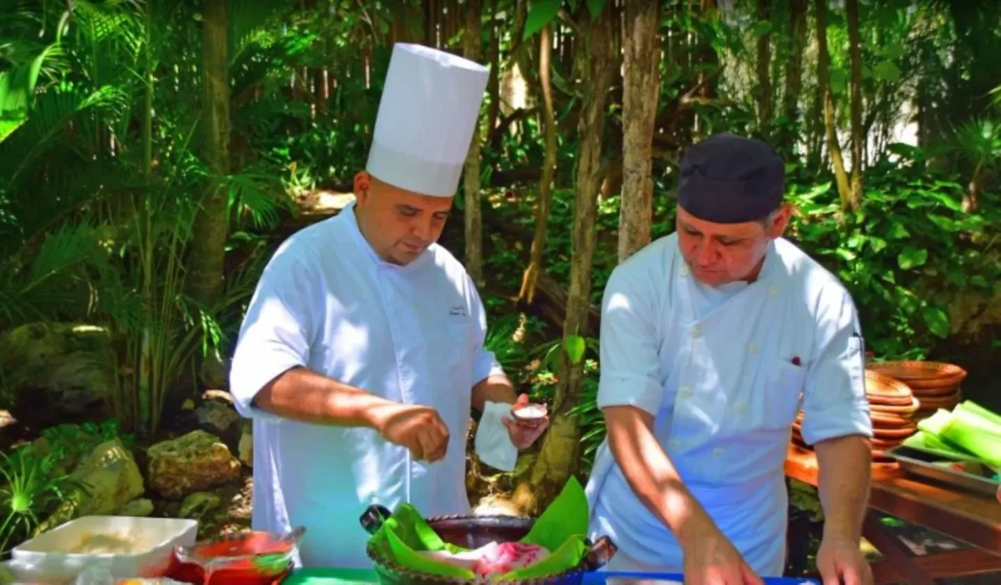 Chefs prepare food outdoors in tropical gardens at Mahekal Beach Front Resort & Spa.