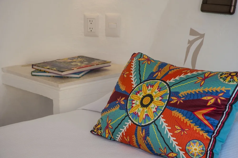 Colorful pillow and bedside shelf in a Garden View room at Mahekal Beach Front Resort & Spa.