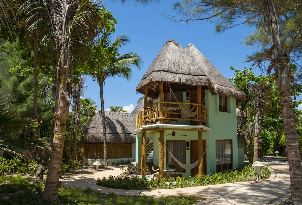 Garden View guest building with thatched roof and balcony at Mahekal Beach Front Resort & Spa.