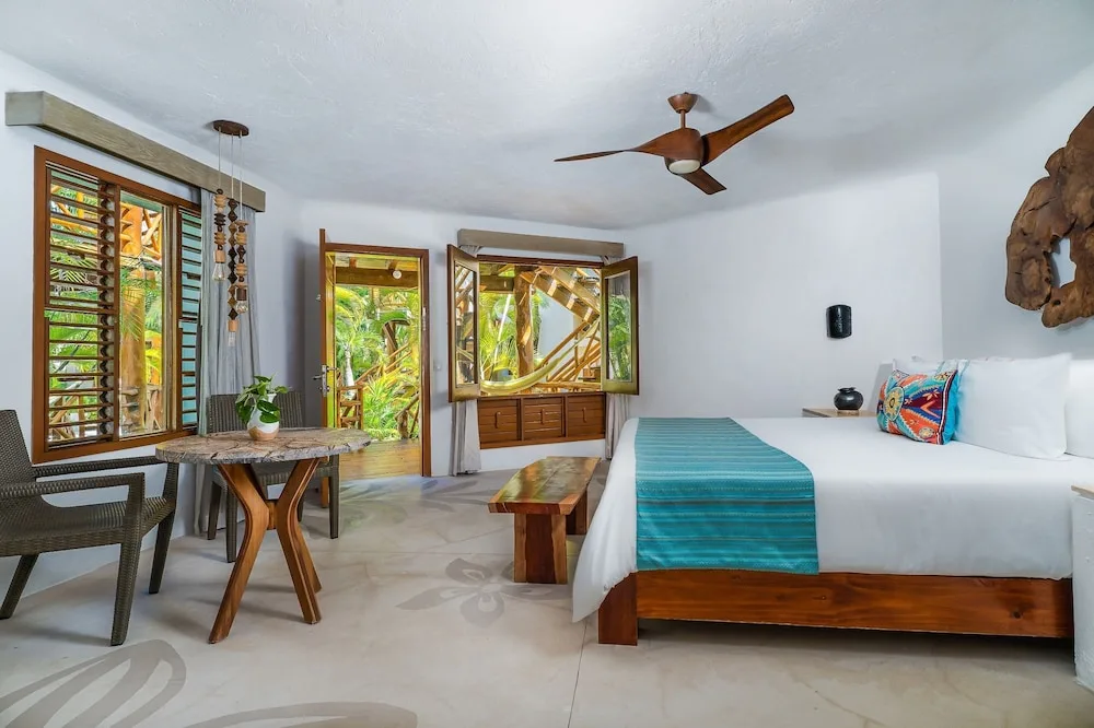 Garden View king bed guest room with patio doors at Mahekal Beach Front Resort & Spa.