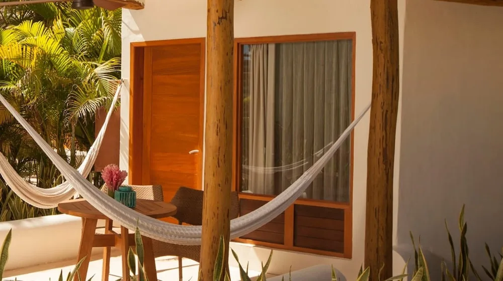 Garden View patio with hammock, table, and sliding doors at Mahekal Beach Front Resort & Spa.