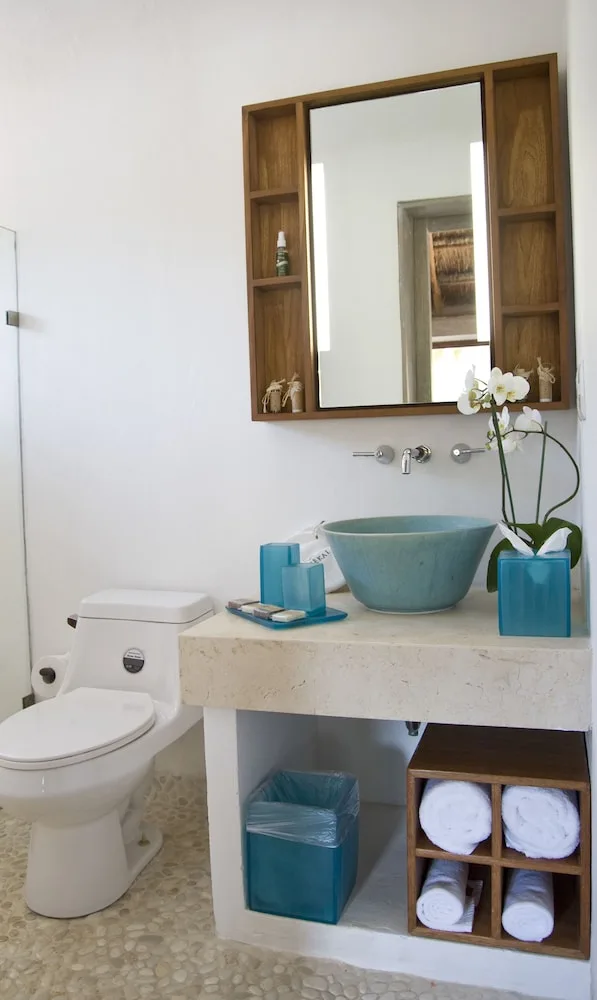 Garden View room bathroom with vessel sink and towels at Mahekal Beach Front Resort & Spa.