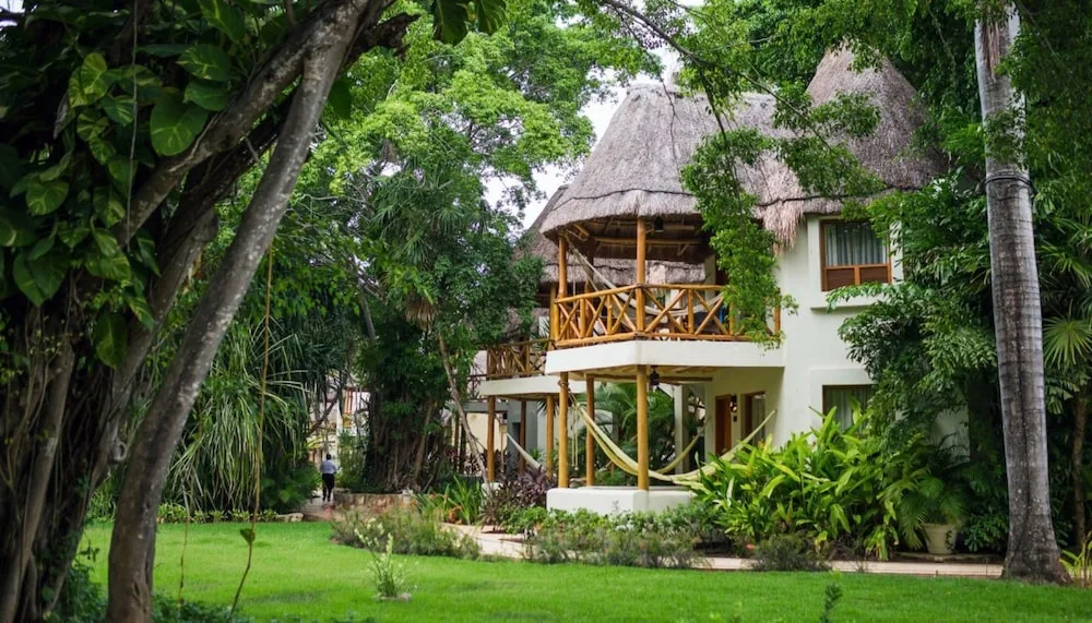 Garden View room building with thatched balcony and hammocks at Mahekal Beach Front Resort & Spa.