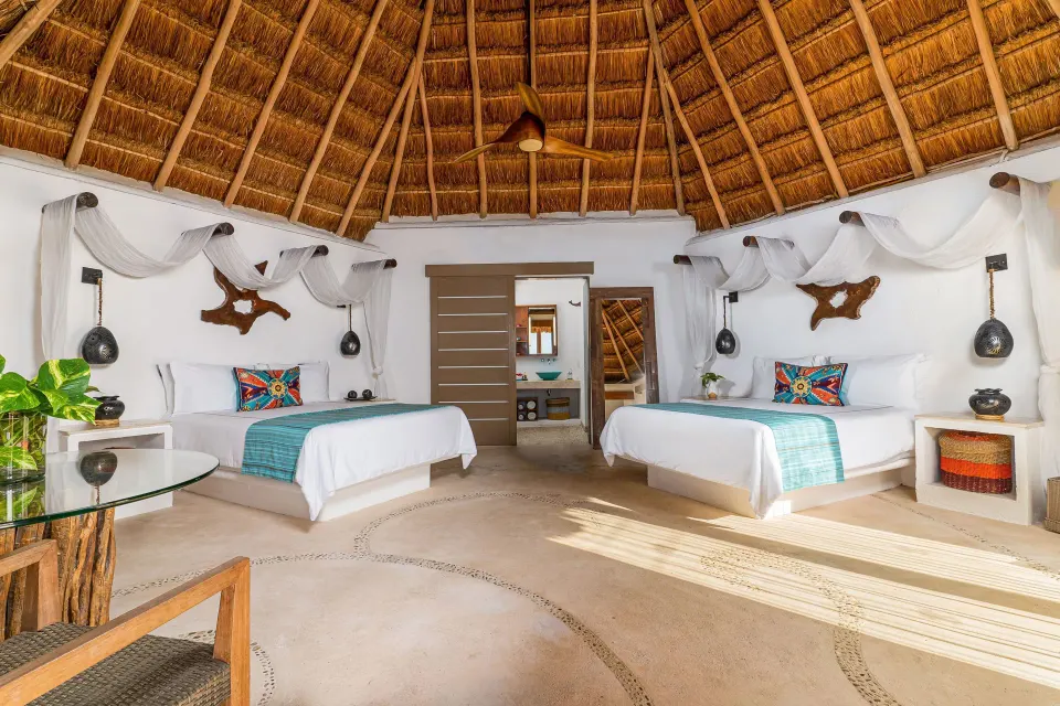 Ocean View room with two beds beneath a thatched ceiling at Mahekal Beach Front Resort & Spa.
