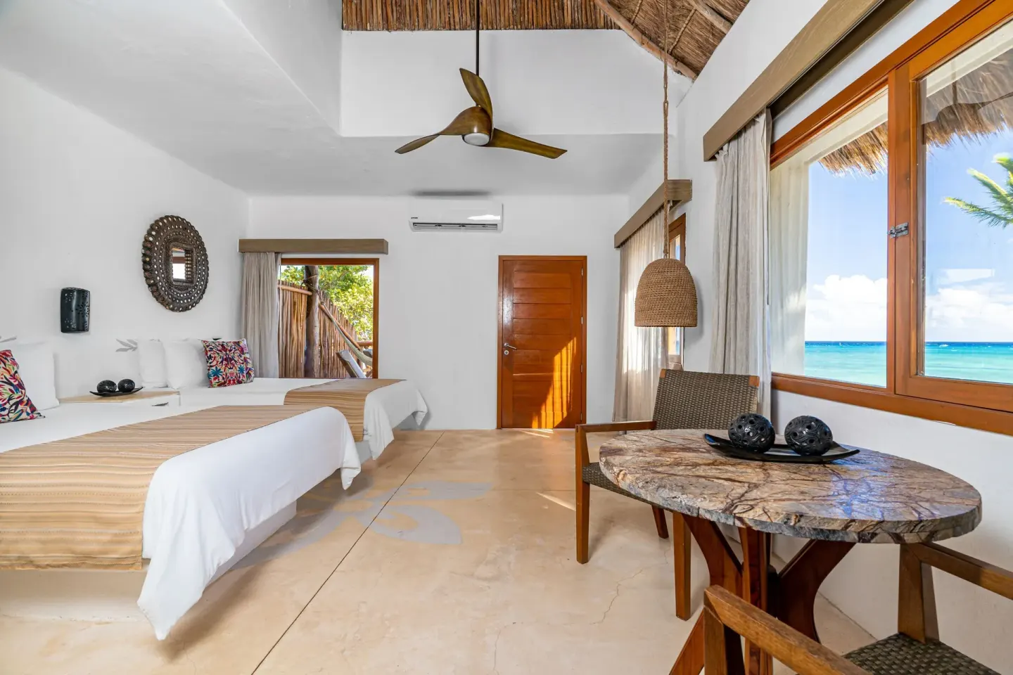 Ocean View room with two beds and large sea-facing window at Mahekal Beach Front Resort & Spa.