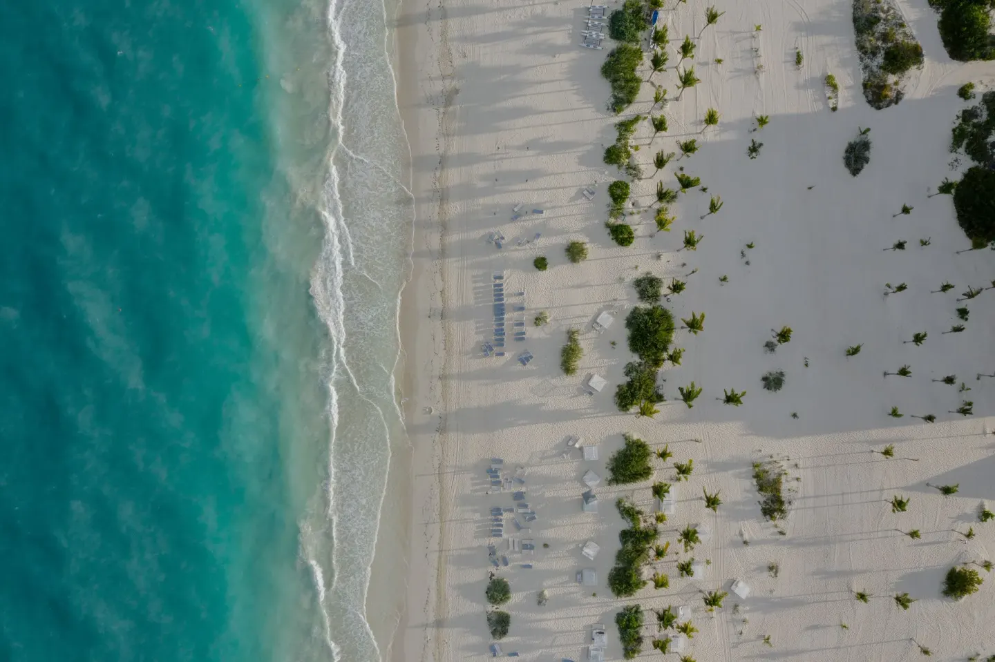 Aerial view of turquoise surf and white sand beach at Majestic Elegance Costa Mujeres.
