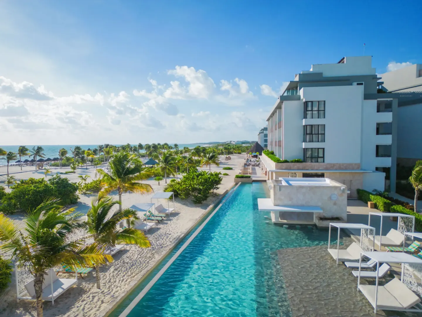Long resort pool beside the beach and guest buildings at Majestic Elegance Costa Mujeres.