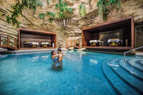 Cave-style spa pool with treatment cabanas at Majestic Elegance Costa Mujeres.