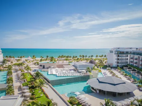 Elevated view of resort pools and oceanfront at Majestic Elegance Costa Mujeres.