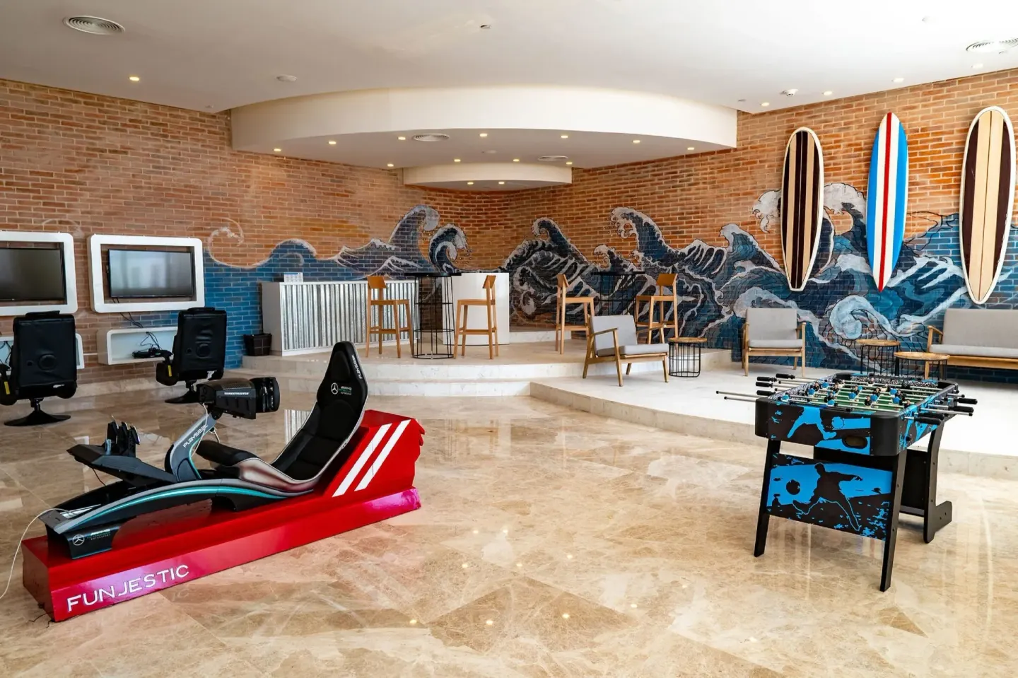 Family game lounge with wave mural at Majestic Elegance Costa Mujeres.
