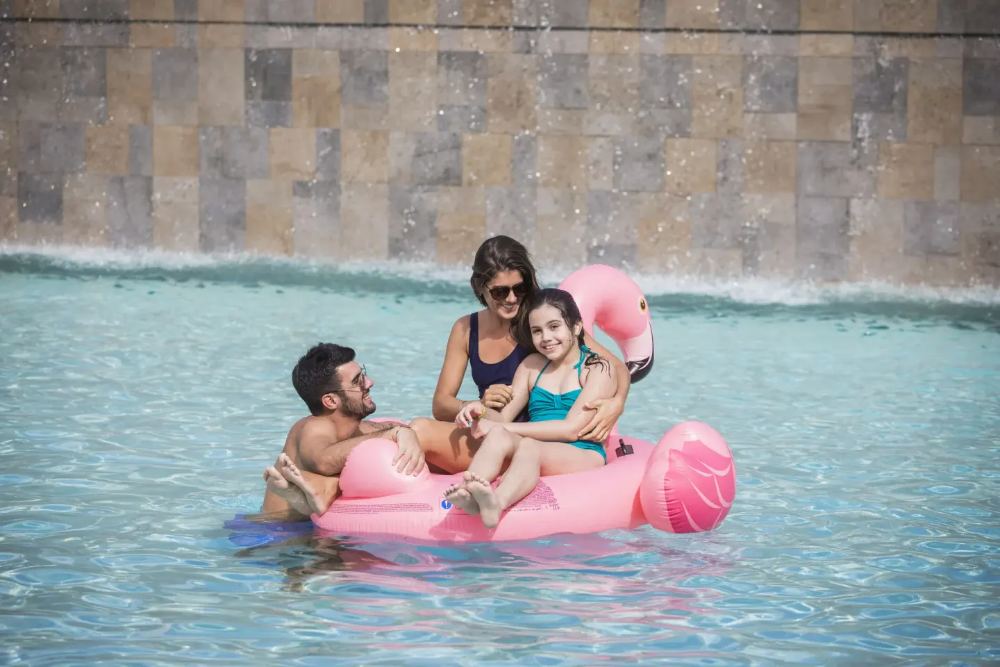 Family floating on a pink pool float at Majestic Elegance Costa Mujeres.