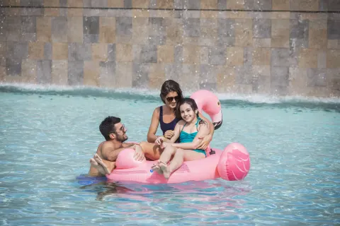 Family floating on a pink pool float at Majestic Elegance Costa Mujeres.