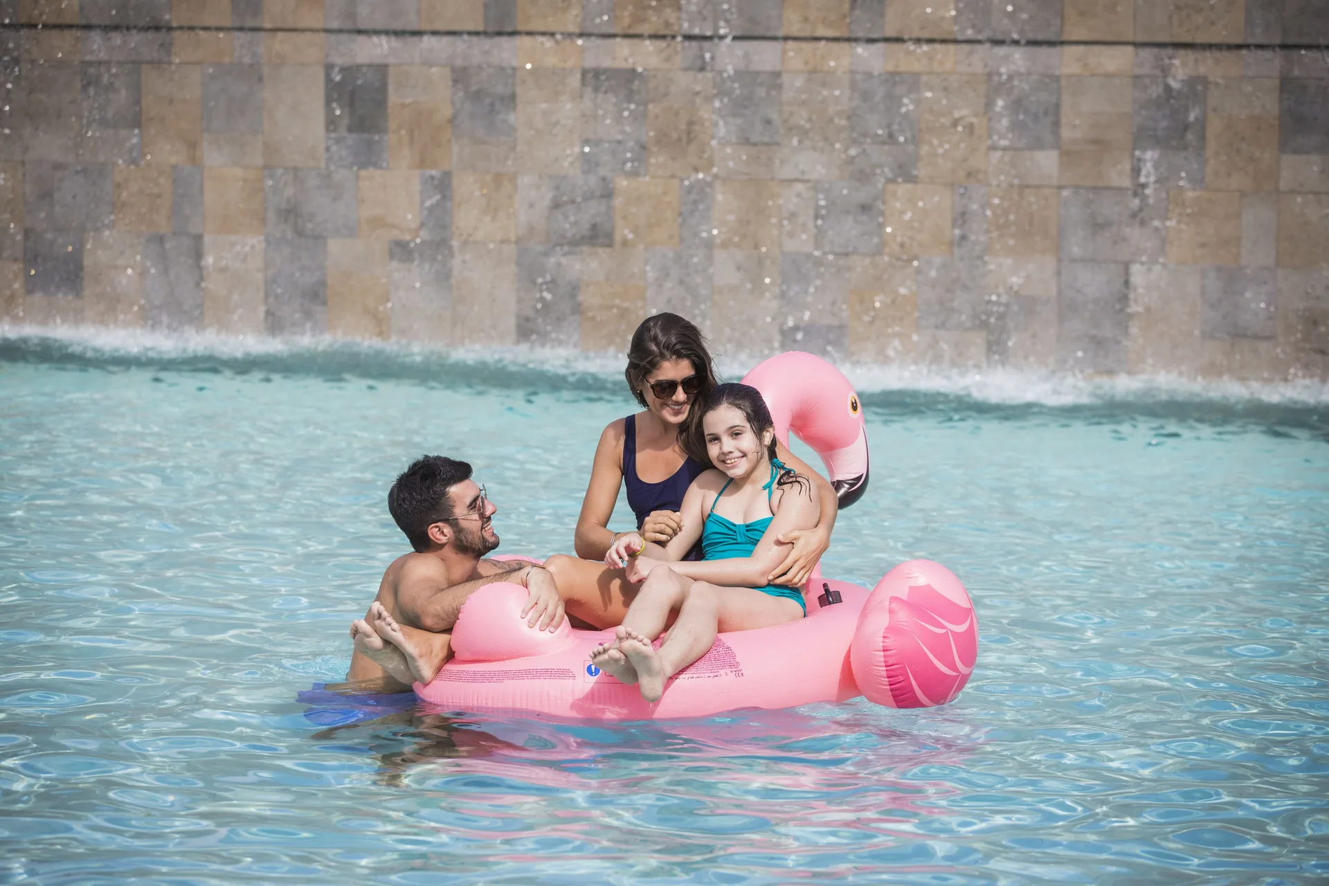 Family floating on a pink pool float at Majestic Elegance Costa Mujeres.