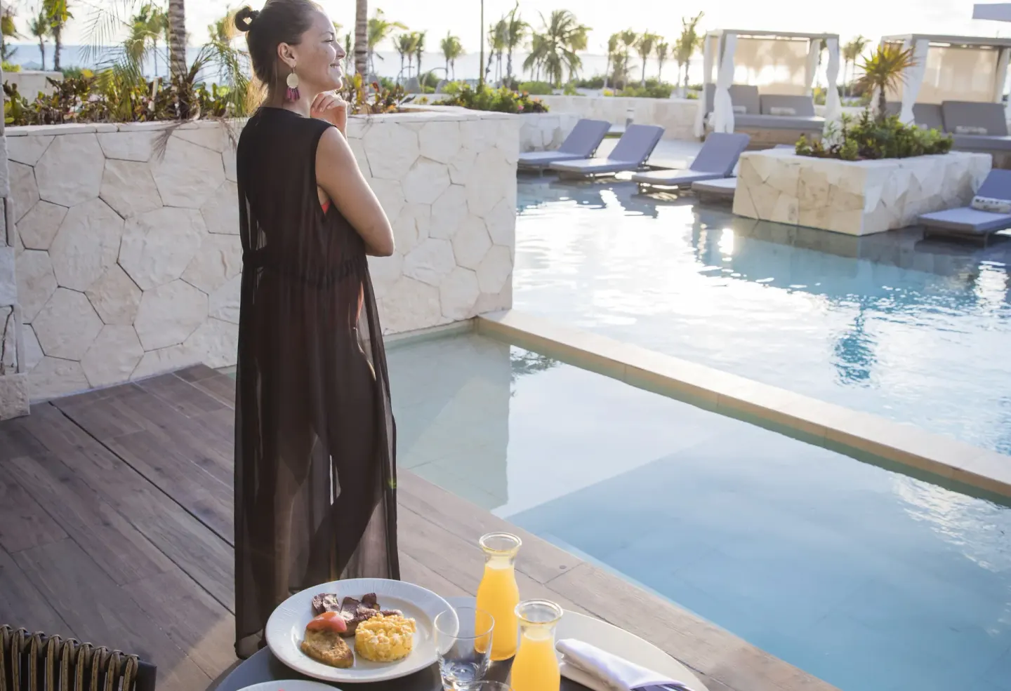 Poolside breakfast setup beside loungers at Majestic Elegance Costa Mujeres.