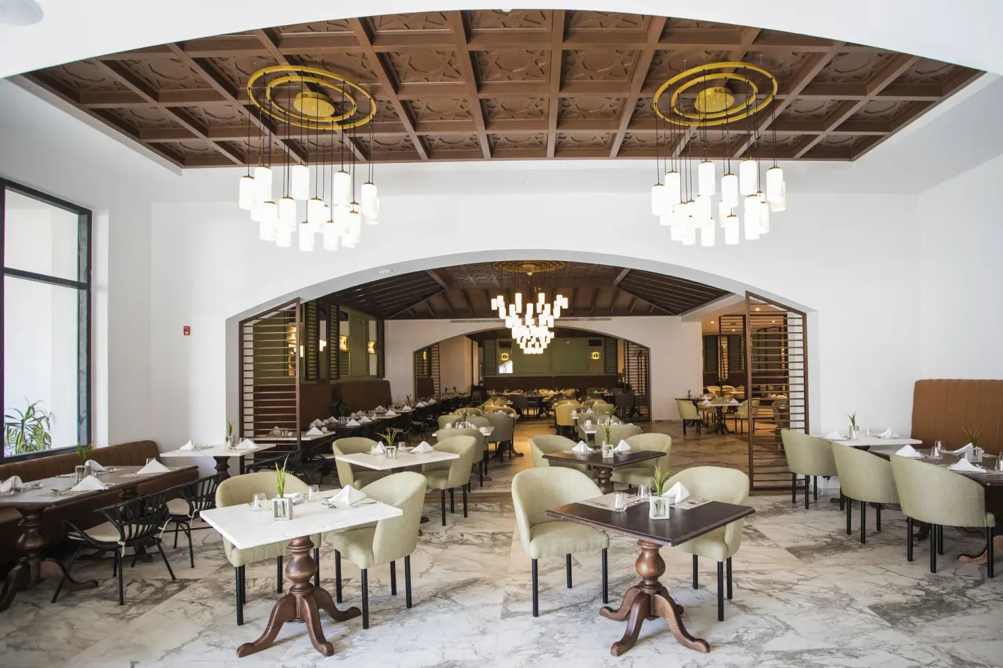 Elegant dining room with chandeliers and arched openings at Majestic Elegance Costa Mujeres.