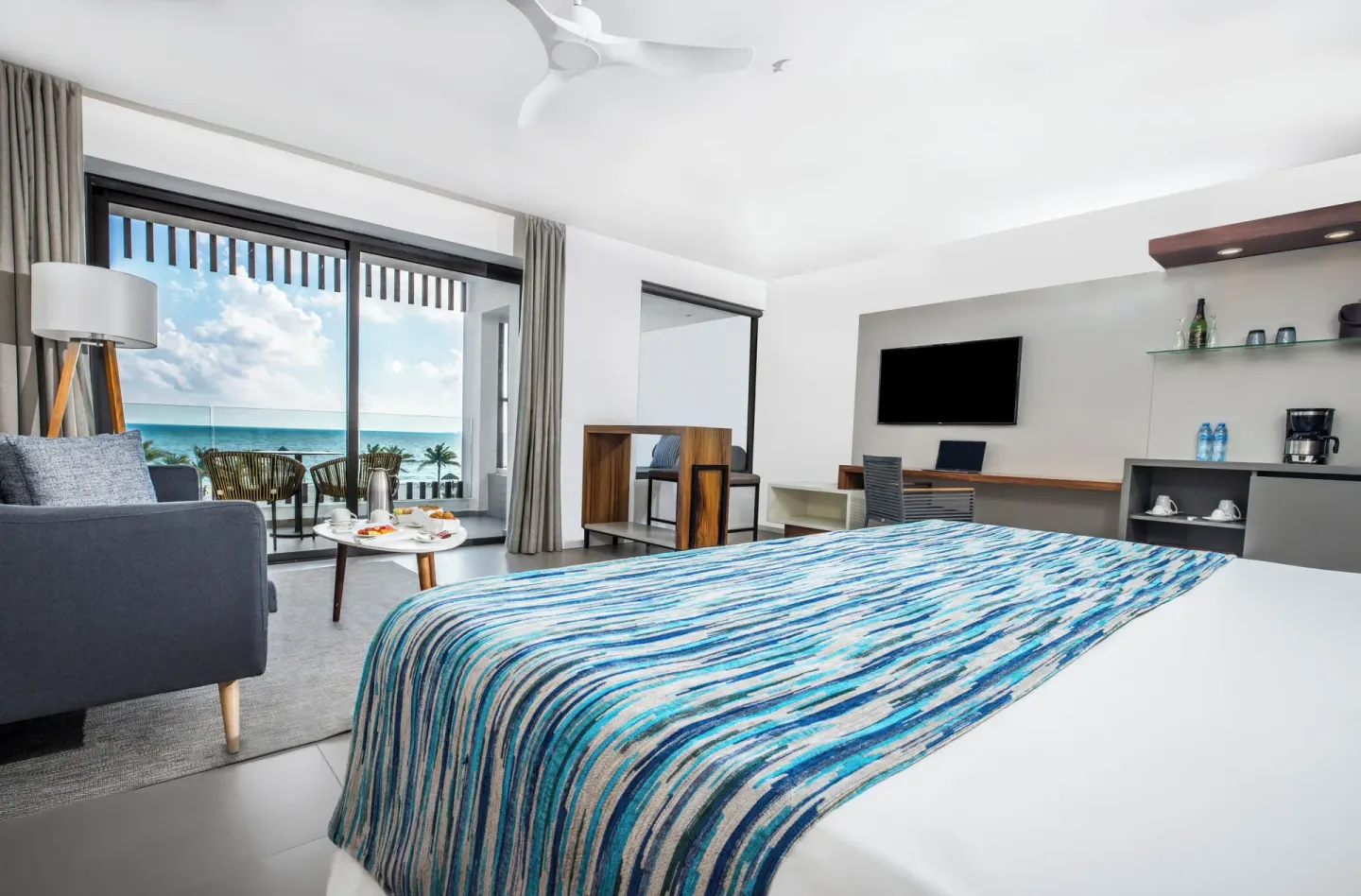 Oceanfront junior suite with king bed and balcony at Majestic Elegance Costa Mujeres.