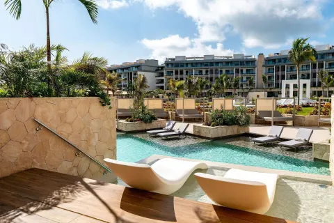 Majestic Elegance Costa Mujeres terrace with loungers and pool at Majestic Elegance Costa Mujeres.