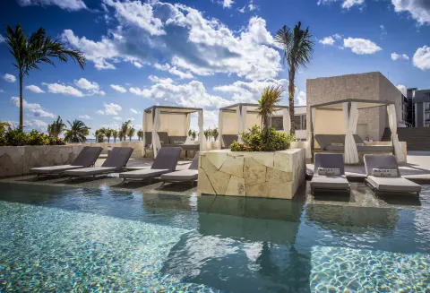 Majestic Elegance Costa Mujeres terrace loungers beside the pool at Majestic Elegance Costa Mujeres.