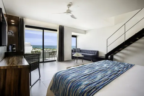 Sky View Suite king bed and balcony ocean view at Majestic Elegance Costa Mujeres.