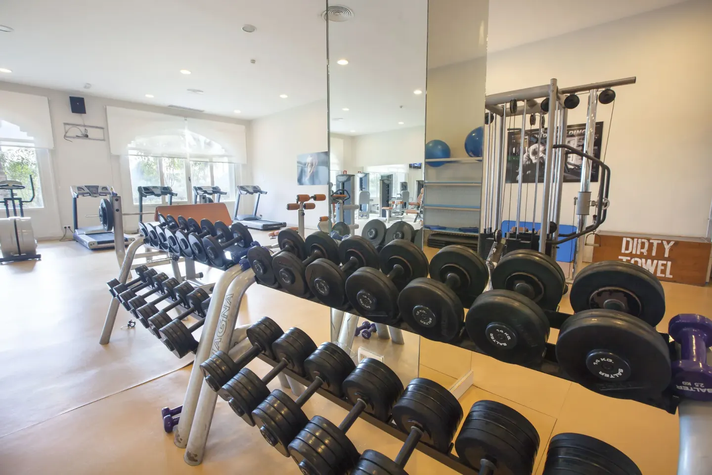 Dumbbell racks and gym mirrors are shown in the fitness center at Majestic Elegance Punta Cana.