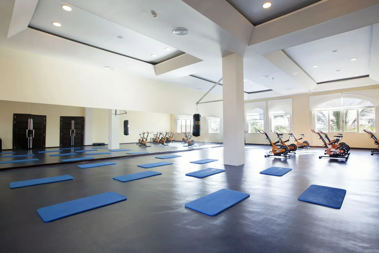 Blue exercise mats and spin bikes are set up in the studio at Majestic Elegance Punta Cana.