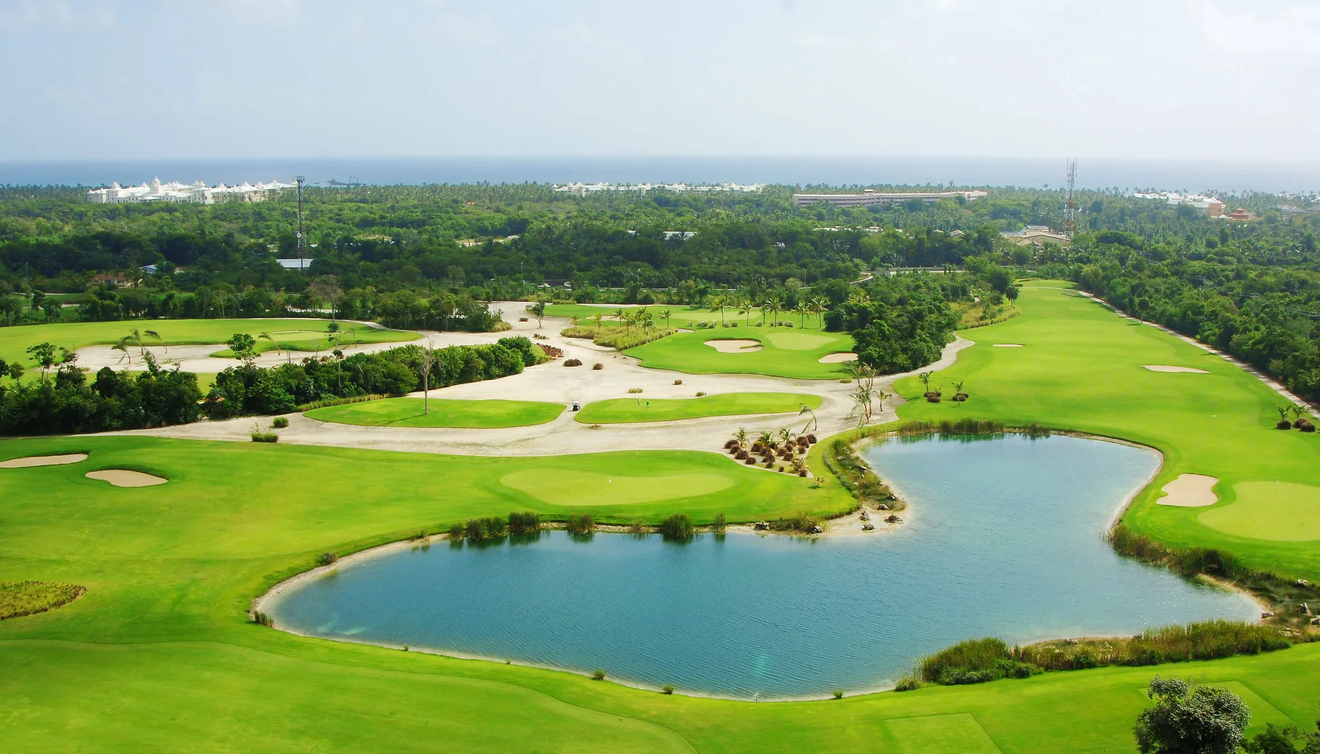 Aerial view of a golf course and lagoon near Majestic Elegance Punta Cana.