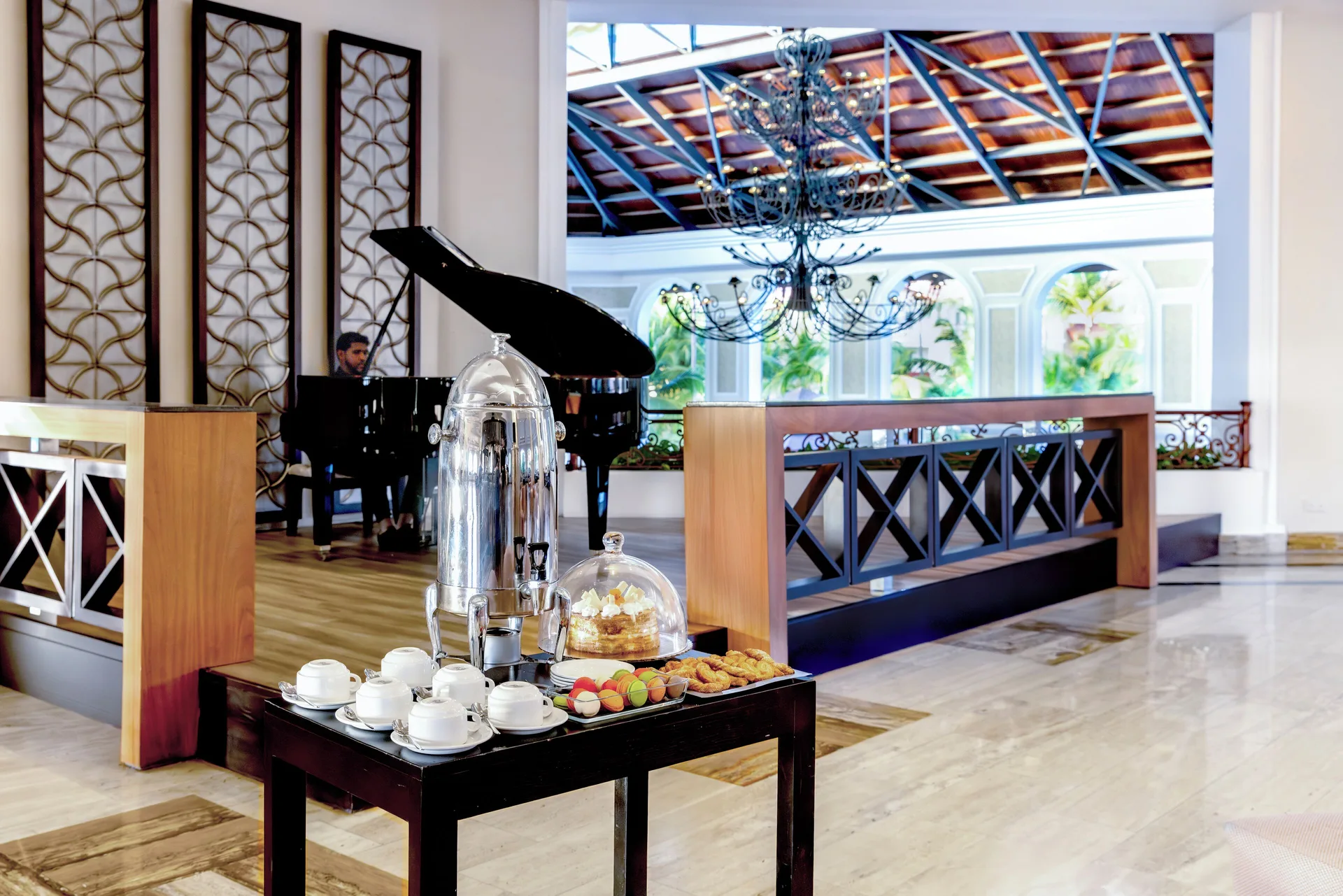 Coffee service and pastries are set near a piano at Majestic Elegance Punta Cana.