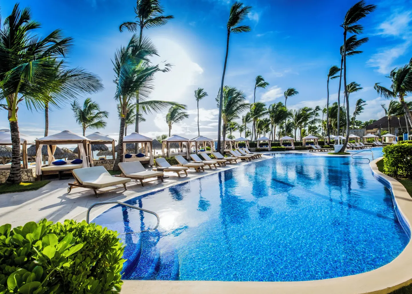 Oceanfront pool with loungers and cabanas at Majestic Elegance Punta Cana.