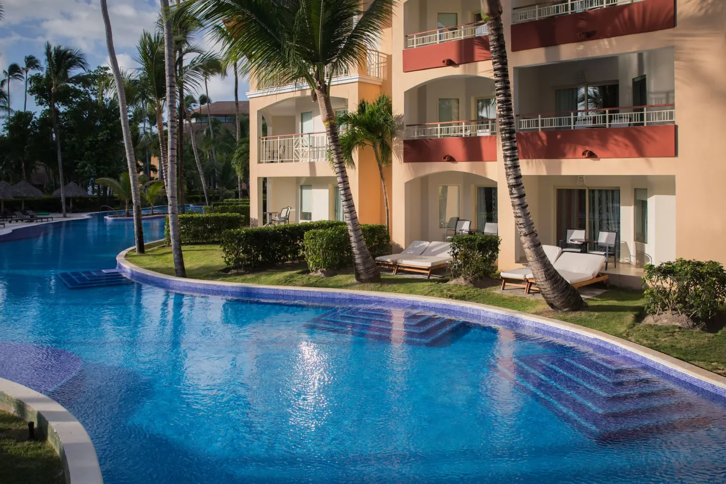 Pool beside ground-floor terraces and loungers at Majestic Elegance Punta Cana.